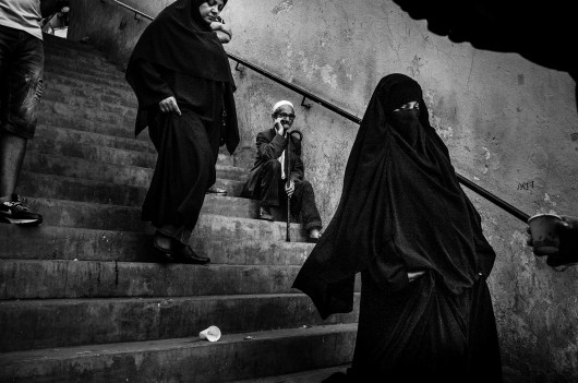 fot. Romain Laurendeau, z projektu Kho, the Genesis of a Revolt, World Press Photo Story of the Year 2020Według raportu UNESCO, 72% Algierczyków poniżej 30 roku życia jest bezrobotnych. Wydarzenia „Czarnego października” z 1988 r., pozostały w pamięci Algierczyków i nadal wzbudzają gniew.  Brutalnie reakcja władzy i  żniwo ponad 500 zabitych w ciągu pięciu dni zapoczątkowały okres zwany „czarną dekadą” przemocy i niepokojów. Po trzydziestu latach skutki tych wydarzeń są nadal obecne. Wysokie bezrobocie prowadzi do frustracji w codziennym życiu, a wielu młodych ludzi czuje się odłączonych od państwa i jego instytucji. W biednych dzielnicach klasy robotniczej, takich jak Bab el-Oued w Algierze, młodzi ludzie szukają schronienia w diki (prywatnych miejscach), które są dla nich „bańkami wolności”, z  dala od spojrzenia społeczeństwa i konserwatywnych wartości społecznych. Jednak to kruche poczucie wspólnoty i solidarności często nie wystarcza, aby złych warunkach życia. W lutym 2019 r. tysiące młodych ludzi z dzielnic robotniczych ponownie wyszło na ulice, co stało się ogólnokrajowym wyzwaniem pod rządami długoletniego prezydenta Abdelaziza Boutefliki.Kho w potocznym języku Afryki oznacza „brat”. Opowiada o genezie buntu. Jest to historia głębokiego niepokoju młodych, którzy znajdują odwagę by rzucić wyzwanie dotychczasowym autorytetom i stają się inspiracją dla reszty populacji. Daje to początek największemu ruchowi protestacyjnemu w Algierii od dziesięcioleci.