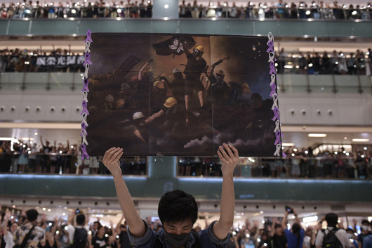 fot. Nicola Asfouti / Agence France PressePierwsze protesty opanowały Hongkong pod koniec marca, były odpowiedzią na propozycje zmian przepisów i chęć wprowadzenia przez rządzących możliwości ekstradycji do Chin kontynentalnych. W kolejnych tygodniach demonstracje przybierały na sile, do protestujących grup prodemokratycznych dołączyli studenci. 12 czerwca dziesiątki tysięcy demonstrantów zgromadziły się wokół Rady Legislacyjnej pracujących nad nowelizacją zapisów o ekstradycji. W kolejnych dniach dochodziło do eskalacji z obydwu stron barykady. 1 października, w dniu 70. rocznicy deklaracji Chińskiej Republiki padły pierwsze strzały. Po początkowym zaproponowaniu odroczenia zmian w przepisach, dyrektor generalny Hongkongu Carrie Lam ostatecznie ogłosiła, że ​​wycofa projekt. Stało się to 23 października, ale żądania protestujących poszerzyły się o wprowadzenie powszechnych praw wyborczych i zwolnienie aresztowanych, napięta sytuacja trwa nadal.