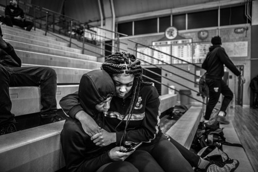 fot. Chris Donovan, Kanada, z cyklu: Those Who Stay Will Be Champions / World Press Photo 2021Drużyna koszykarska Flint Jaguars z Flint w stanie Michigan w USA uosabia wysiłki mające na celu pielęgnowanie stabilności, zachęcanie do wzajemnego wsparcia i wzmacnianie ducha wspólnoty w mieście walczącym o przetrwanie.Flint, miejsce narodzin General Motors, walczy z emigracją spowodowaną gwałtownym upadkiem przemysłu samochodowego, kryzysem zdrowotnym spowodowanym przez władze zmieniające źródła zaopatrzenia w wodę bez odpowiednich zabezpieczeń oraz systemowym zaniedbaniem.Koszykówka jest integralną częścią kultury Flint. Przez dziesięciolecia stale konkurowały tam ze sobą 4 licealne drużyny. Teraz w mieście została tylko jedna szkoła średnia. Flint Jaguars powstały w 2017 roku, łącząc zespoły dwóch ostatnich szkół, które przetrwały do tego czasu.W 2020 roku zespół walczył o odwrócenie złej passy. Do marca byli przygotowani do awansu do finału ligi, wygrywając więcej meczów niż łącznie w poprzednich trzech latach łącznie. Ich baraż zakończył się przedwcześnie, gdy COVID-19 wymusił odwołanie sezonu. Niemniej jednak sportowcy-studenci zasmakowali wspólnego sukcesu.