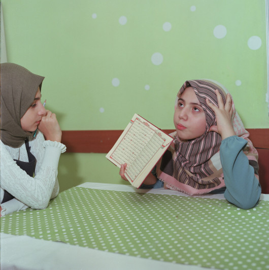 fot. Sabiha Çimen, z projektu Hafız: Guardians of the Qur’an Muzułmanki, którzy całkowicie zapamiętali treść Koranu, mogą używać tytułu „Hafız” przed ich imionami. Wierzą, że ktokolwiek zapamięta świętą księgę i zastosuje się do jej nauk, zostanie nagrodzony przez Allaha i zyska wyższy status w Raju. Praktyka sięga czasów, gdy analfabetyzm był powszechny, a papier i welin były zbyt drogie, więc Hafizy były postrzegane jako strażnicy świętego słowa, utrzymując je przy życiu dla przyszłych pokoleń.