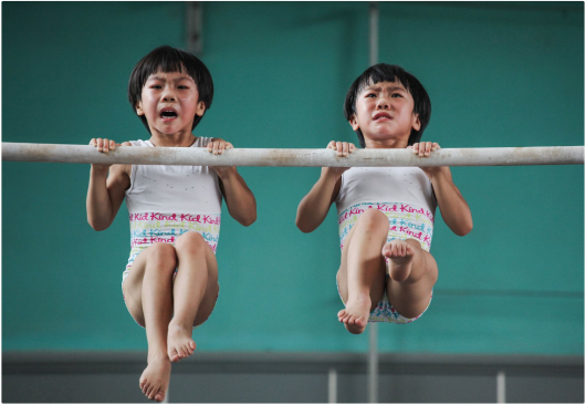 Peng Yuan „The twins’ gymnastics dream“, III miejsce w kategorii Storyboard Siena International Photo Awards 2018 | „Kiedy odkryłem te bliźniaki w szkole gimnastycznej, postanowiłem uchwycić ich koordynację telepatyczną, wzajemną pomoc i wzajemne zależności w codziennym treningu. Skupiłem się również na uchwyceniu ich indywidualnych różnic w treningu, szczególnie w prostych ruchach obowiązkowych. Ciężko pracowałem, aby znaleźć i uchwycić ich różnice w nadziei ujawnienia cech i form bliźniaków w sporcie wyczynowym. Zdjęcia zostały zrobione głównie w szkole gimnastycznej w Jining City w Chinach. Dwoje dzieci urodziło się w 2007 roku. Ich imiona to Liu Bingqing i Liu Yujie“ - opisuje Peng Yuan.
