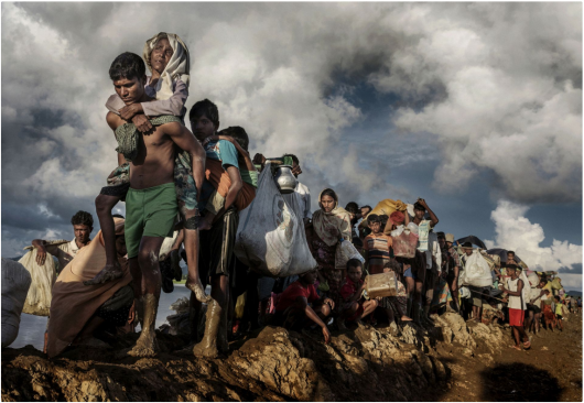Paula Bronstein „The unwanted, the Rohingya“, III miejsce w kategorii Storyboard Siena International Photo Awards 2018 | Bezpaństwowcowi, splątani i niechciani: przez większość buddyjskiej Mjanmy zmagał się z głęboko zakorzenioną nienawiścią do społeczności Rohingya (w zachodnim stanie Rakhine). Ta muzułmańska mniejszość etniczna była zawsze uważana za „nielegalnego imigranta z Bangladeszu“ i pozbawiona praw obywatelskich. Rząd Mjanmy nałożył surowe ograniczenia na swobodę przemieszczania się, edukację państwową, służbę cywilną i opiekę zdrowotną. Rohingya utrzymuje, że są oni rdzennymi mieszkańcami Zachodu. W efekcie atak na siły bezpieczeństwa państwowego przez powstańców Rohingya doprowadził do brutalnej represji wojskowej, która zmusiła ponad połowę kraju (ponad miliona ludzi) do ucieczki do sąsiedniego Bangladeszu, tworząc najszybszy transgraniczny exodus. Wielu uchodźców opowiadało o prawdziwym horrorze: gwałtach, zabójstwach, spaleniach setek wiosek. Poza tym tysiące dzieci, które podróżują same, są poważnie zagrożone handlem i wyzyskiem.