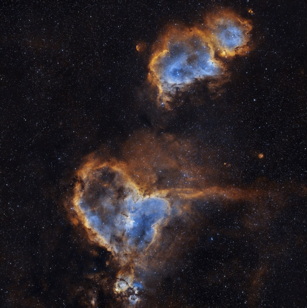 <strong>Royal Society Publishing Photography Competition, Zwycięzca kategorii Astronomia „Serce i dusza”, fot. Imran Sultan </strong></br>

Serce i Dusza to dwie magiczne mgławice znajdujące się w konstelacji Kasjopei. Aby uchwycić ich zawiłości, fotografowałem je łącznie przez 14 godzin (w ciągu trzech nocy jesienią 2023 roku), najdłużej ze wszystkich obiektów jakie fotografowałem. Serce i Dusza są oświetlone przez emisję zjonizowanego gazu w obszarze gwiazdotwórczym, pokazanym tutaj w palecie kolorów HOO. Użyłem specjalnego filtra, który przepuszcza tylko określone długości fal światła (w szczególności długości fal odpowiadające emisji H-alfa i O-iii, które są powszechnie emitowane przez gaz w mgławicach emisyjnych). Sprzęt: ZWO ASI533MCPro: 164x300 s; flat/bias/dark, filtr Optolong L-Ultimate.