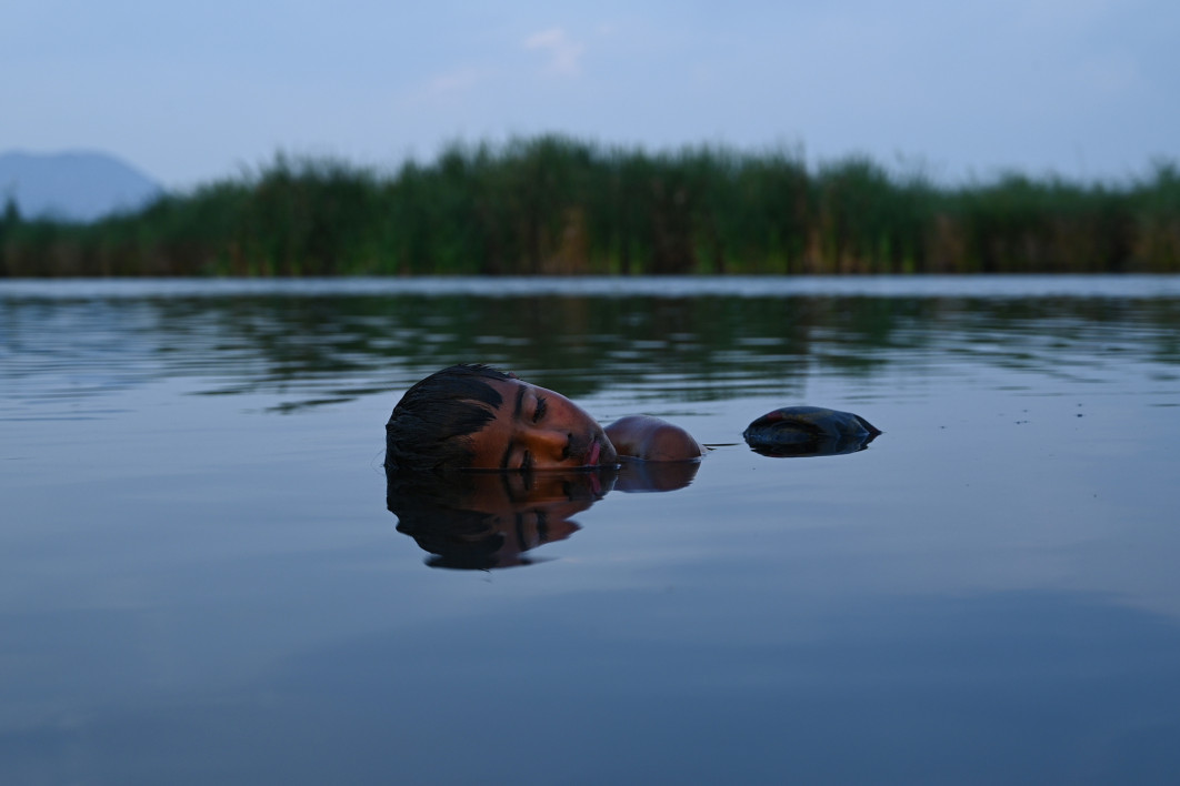 Fot. Karen Paz Gonzalez, "Damián y el espejo del lago", Damián unosi się na wodzie na mokradłach Xochimilco w chwili spokoju. Mieszka wśród chinampas, gdzie codzienność splata się z rytmem jeziora. Gdy otula go własne odbicie, jego ciało zdaje się stawać częścią krajobrazu. Zdjęcie próbuje uchwycić więź między dzieciństwem a naturą oraz ciszę obecną w miejscach, gdzie woda pozostaje symbolem pamięci / Female in Focus x Nikon 2025